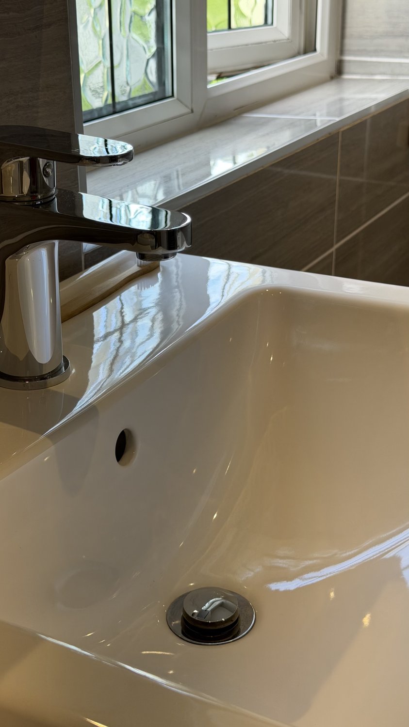 Close-up of a spotless basin and chrome tap after professional cleaning
